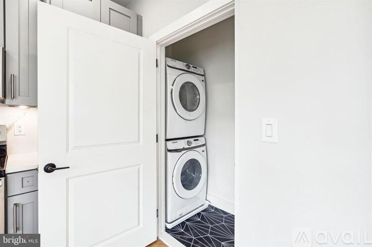 A white door is open to a laundry room with a washer and dryer.