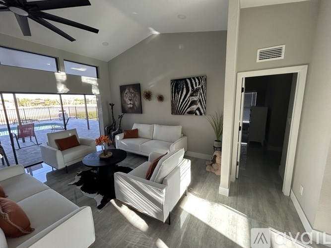 A living room with white furniture and a ceiling fan.