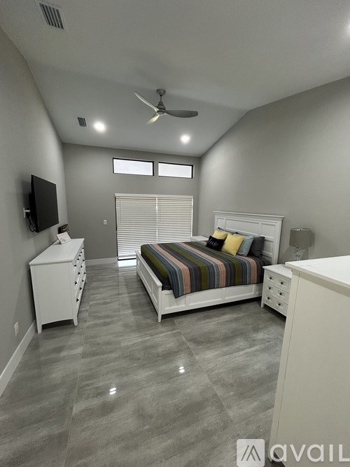 A bedroom with a bed, dresser, and television.