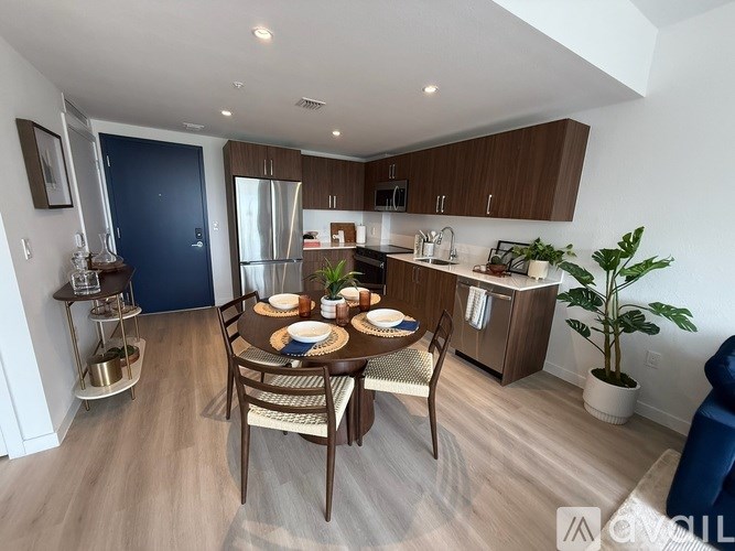 A modern kitchen with a dining table set for two.
