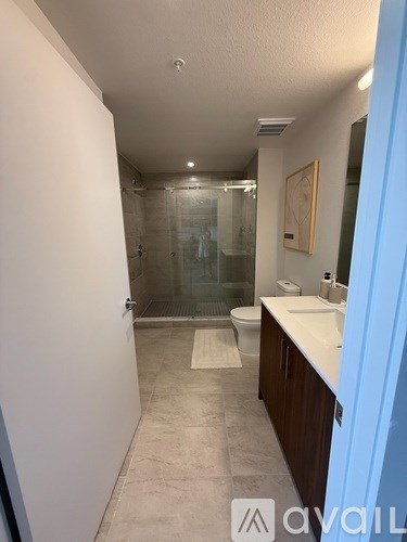 A bathroom with a walk-in shower, toilet, and sink.