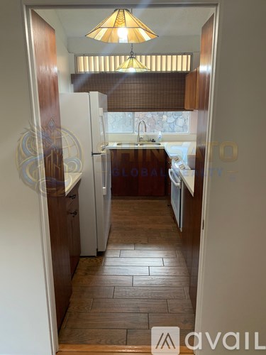 A room with wooden flooring and a window with blinds.