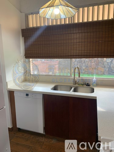 A room with wooden flooring and a window with blinds.