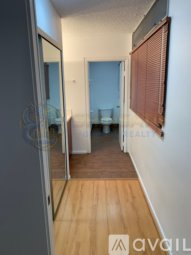 A room with wooden flooring and a white wall.