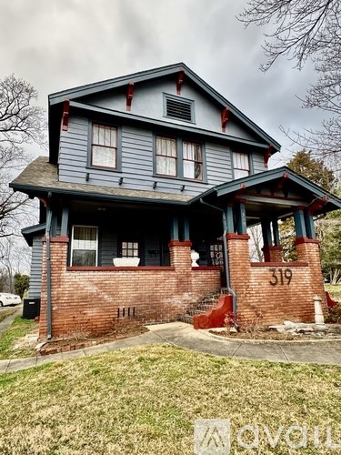 House number 319 with a grey roof and a red brick base.