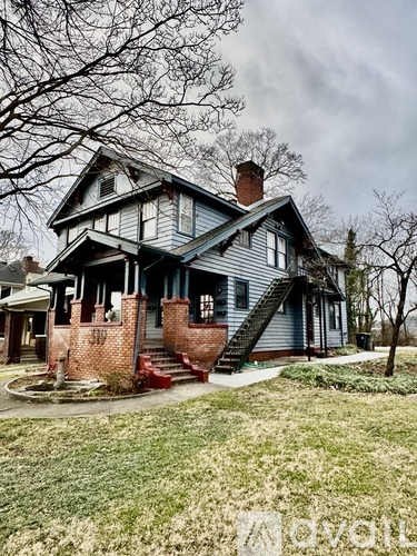 A house with a blue siding and a brick chimney.