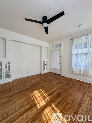 A kitchen with white cabinets and a wooden floor.