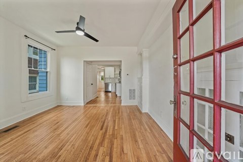 A kitchen with white cabinets and a wooden floor.