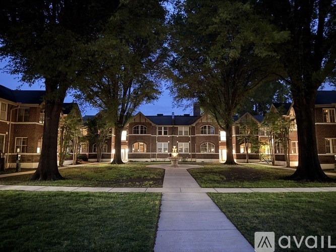 A building with a walkway in front of it is lit up at night.
