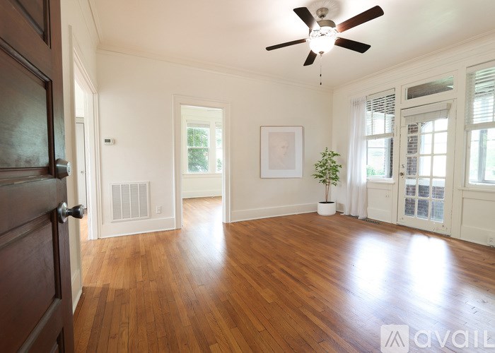 A room with wooden floors and a ceiling fan.