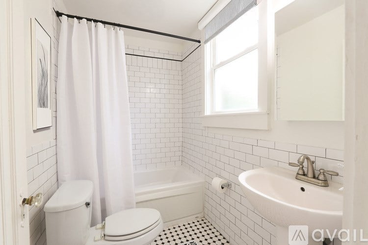 A white bathroom with a toilet, sink, and bathtub.