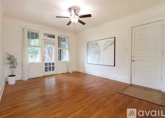 A room with wooden floors and a ceiling fan.