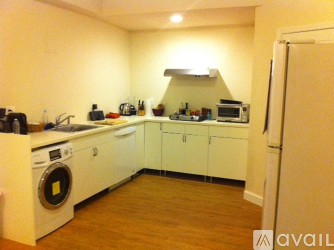 A kitchen with white appliances and cabinets.