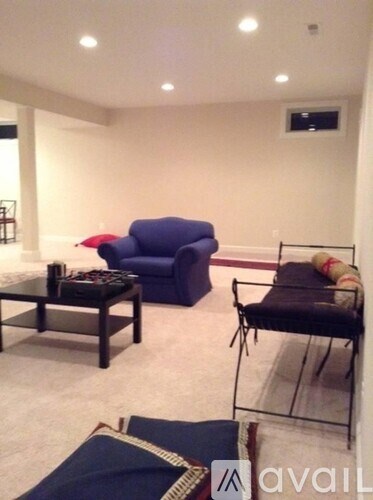 A living room with a blue couch and a black chair.