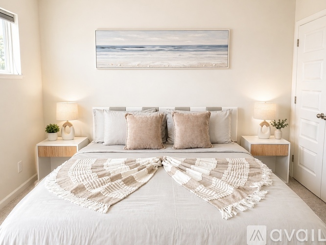 A bedroom with a large bed and a painting above it.