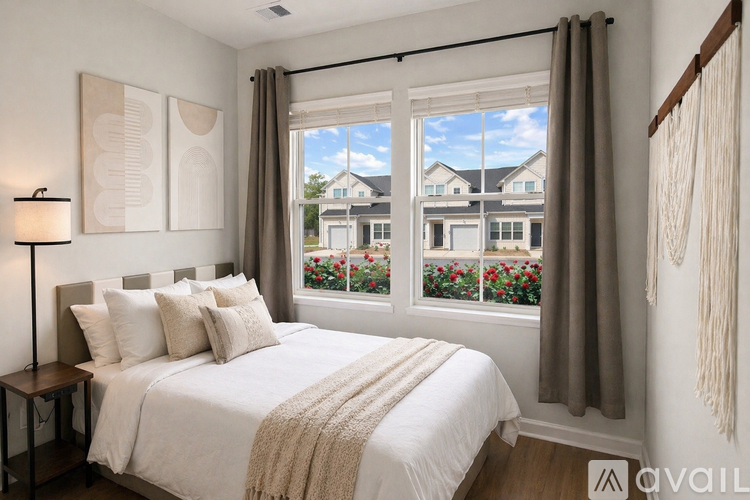 A bedroom with a large bed and a window overlooking a garden.