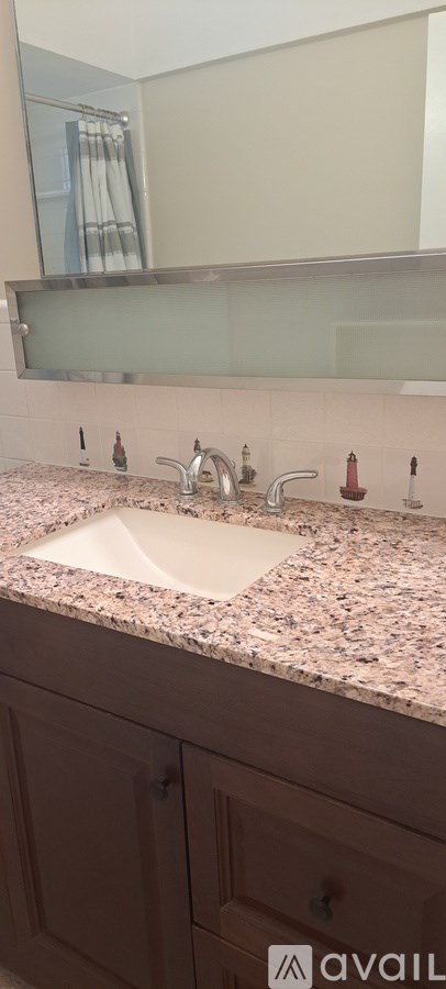 A bathroom with a sink and a mirror above it.