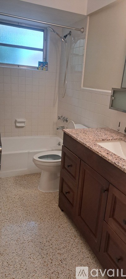 A bathroom with a toilet, sink, and shower.