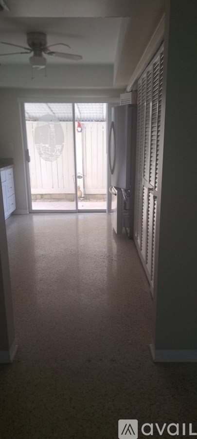 A long hallway with a ceiling fan and sliding glass doors.