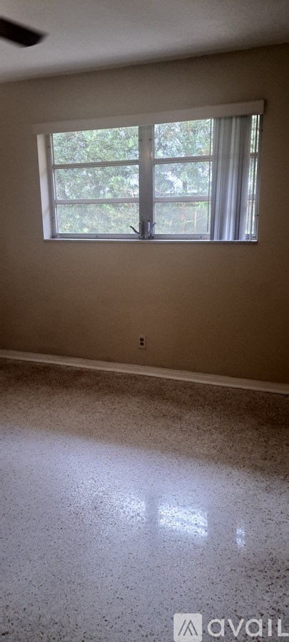 A room with a window and a floor that reflects light.