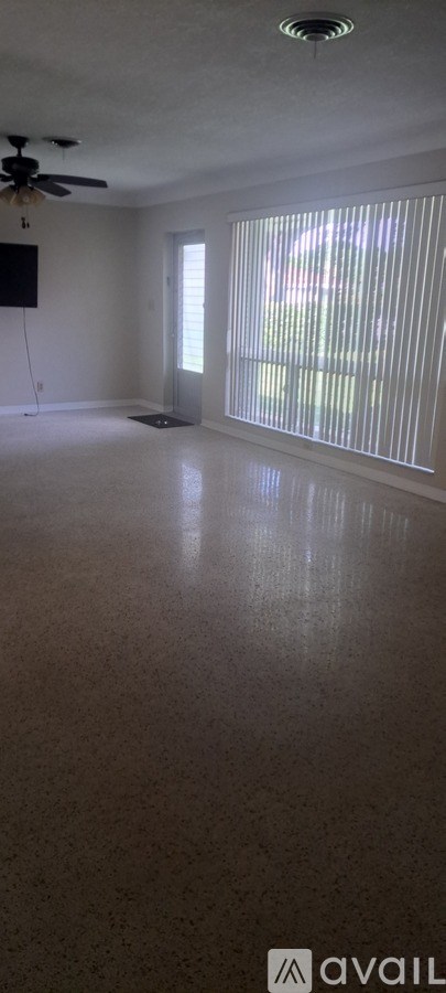A room with a ceiling fan and a window.