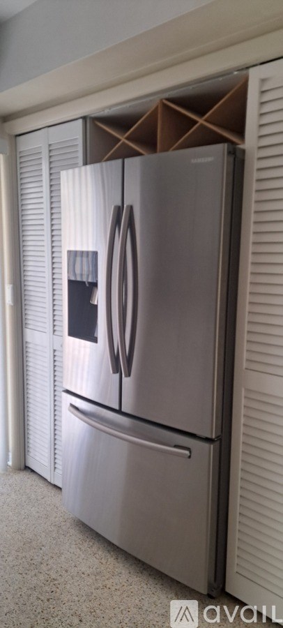 A stainless steel refrigerator with a door open and a box inside.