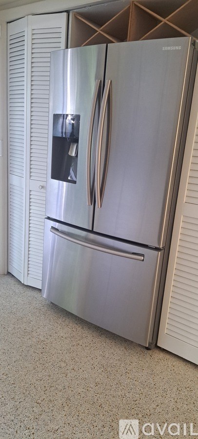 A silver refrigerator with a black box on the door.