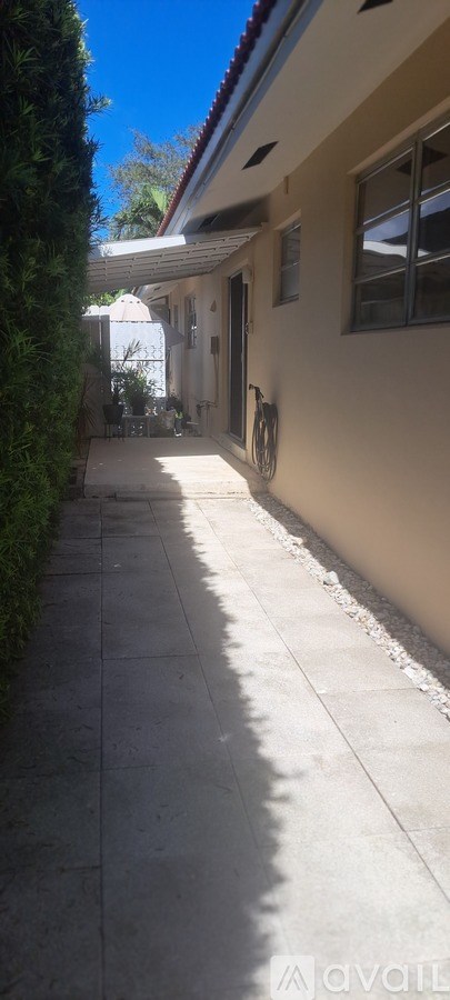 A sunny day with a clear blue sky and a white building with a red roof.