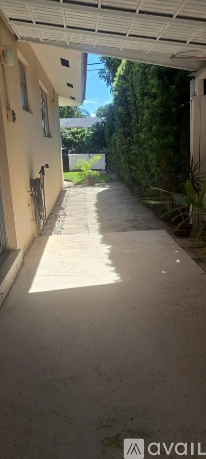 A sunny day in a residential area with a pathway leading to a house.