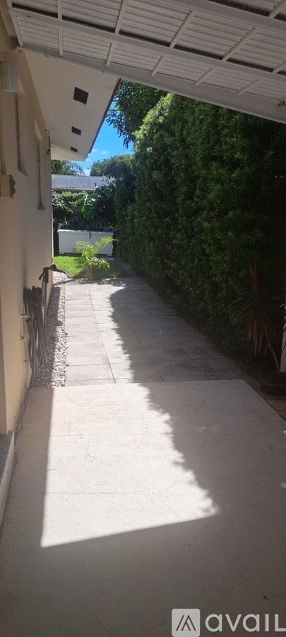 A sunny day with a clear blue sky and a white building with a white roof.