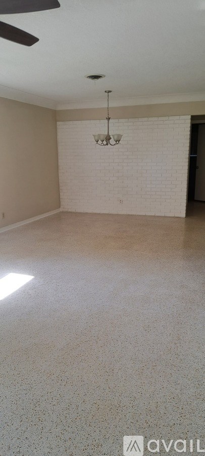 A room with a white brick wall and a chandelier.