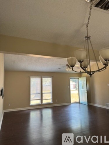 A room with a chandelier and a large window.