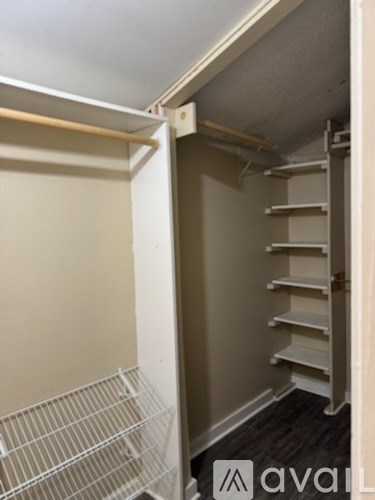 A small pantry with a white door and shelves.
