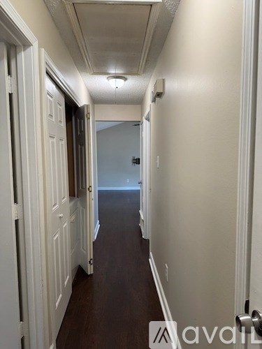 A long hallway with white doors on both sides.
