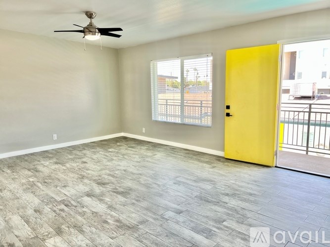 A room with a yellow door and a ceiling fan.