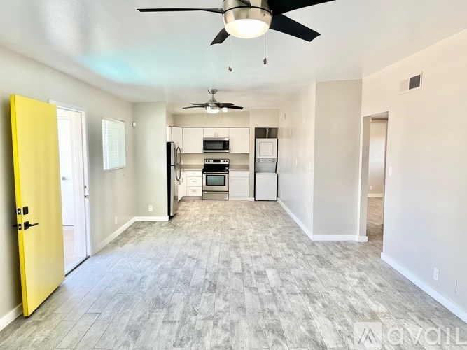 A yellow door opens to a kitchen with a fan.