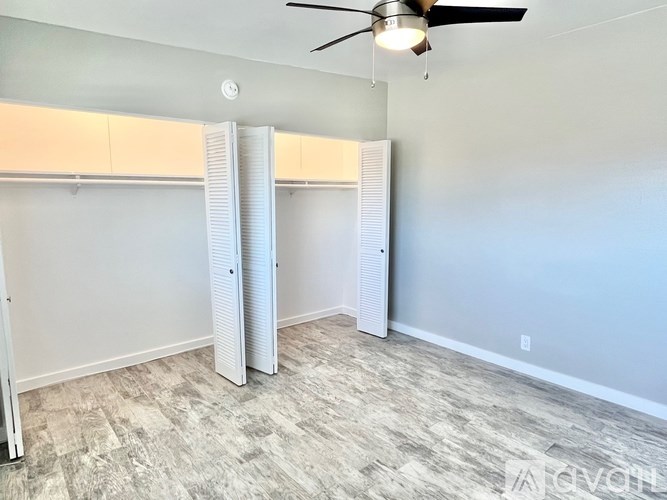 A room with a ceiling fan and sliding doors.