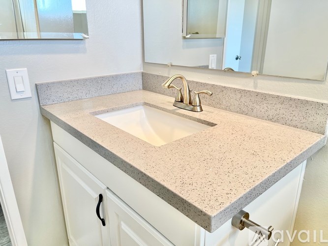 A bathroom sink with a granite countertop and a silver faucet.