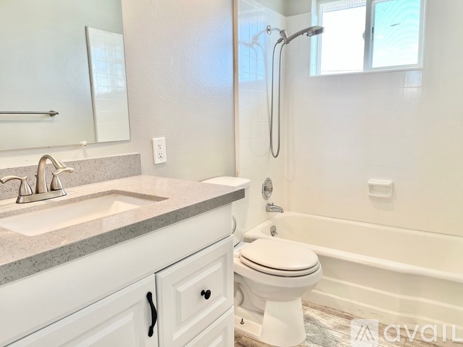 A white bathroom with a sink, toilet and bathtub.