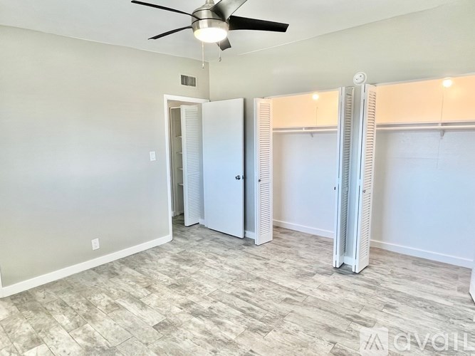 A room with a ceiling fan and a door.