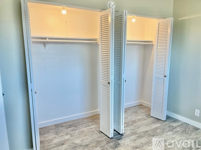 A room with two white closets and a light on the ceiling.