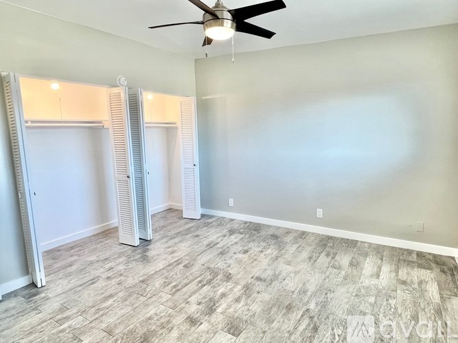 A room with a ceiling fan and a light fixture.