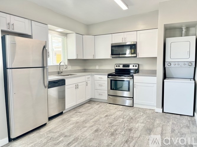 A kitchen with a refrigerator, oven, microwave, and dishwasher.