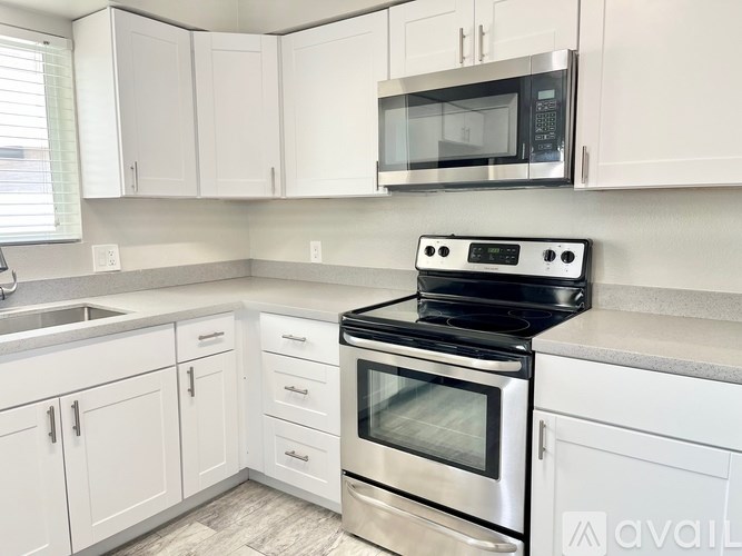 A kitchen with white cabinets and a black stove top oven.