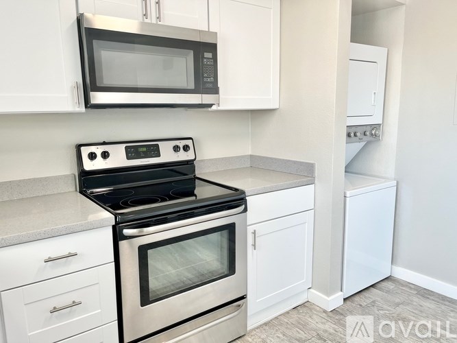 A kitchen with a stove, microwave, and cabinets.