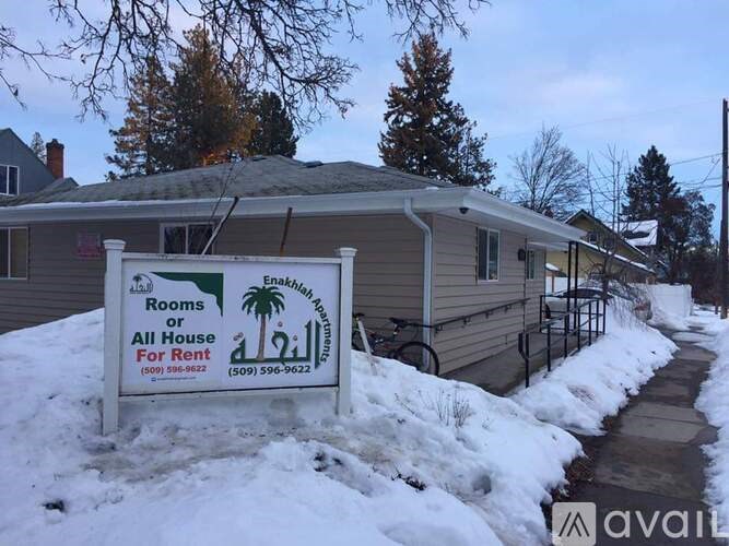A sign advertising rooms or all house for rent in front of a house.