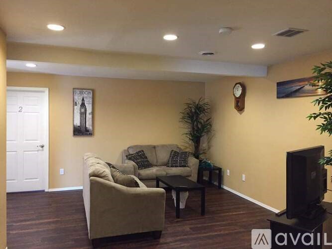 A living room with a couch, a coffee table, and a television.