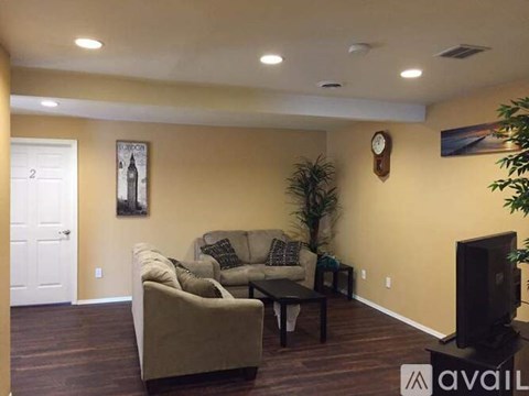 A living room with a couch, a coffee table, and a television.