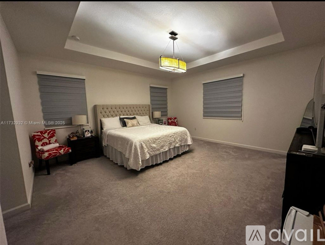 A bedroom with a bed, nightstand, and chair.