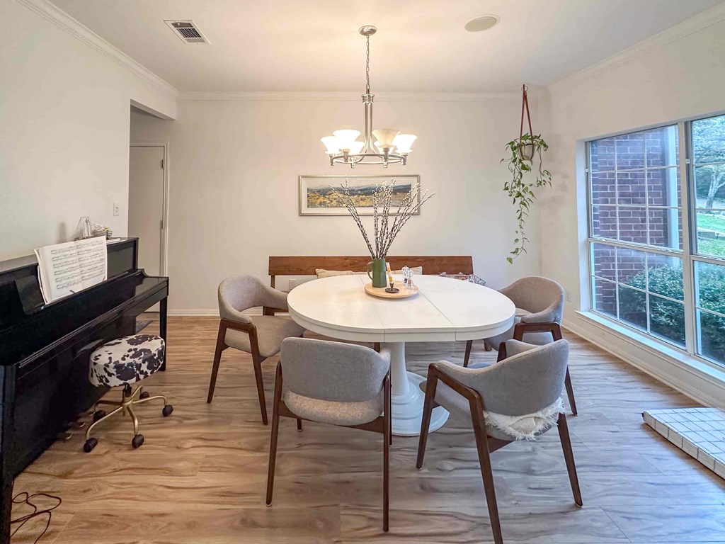 A dining room with a white table and chairs.